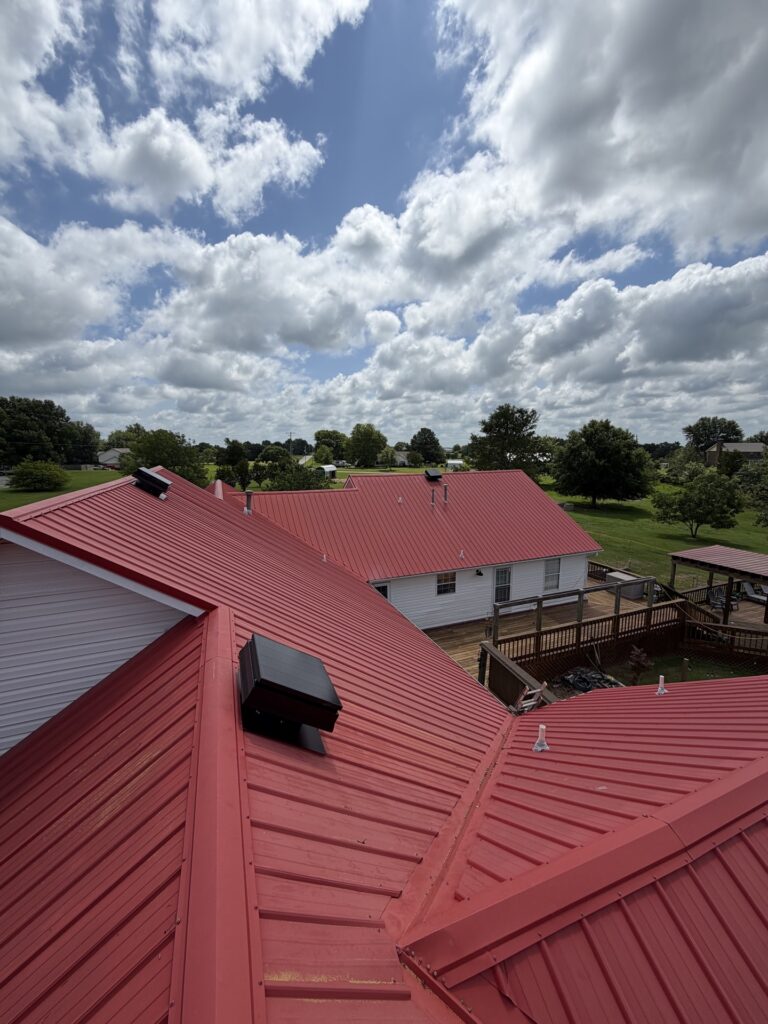 Solar attic fan installed on a red metal roof